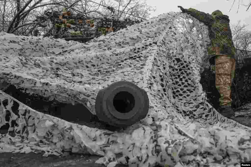 Un soldado ajusta el camuflaje sobre un obús autopropulsado 2S1 Gvozdika. Después de 22 meses de guerra a lo largo de una línea de frente de 1.000 kilómetros, ni Ucrania ni Rusia están ganando terreno significativo y predominan las batallas de desgaste.