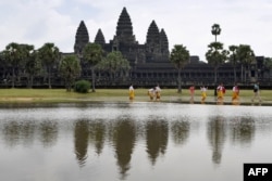 This photo taken on October 12, 2020 shows tourists walking past the Angkor Wat temple in Siem Reap province