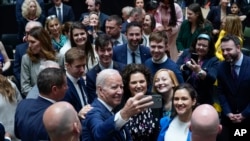 Rais wa Marekani Joe Biden akipiga picha za selfie na wageni baada ya kuhutubia Chuo Kikuu cha Ulster, Belfast, Ireland ya Kaskazini, April 12, 2023.