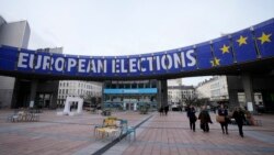FILE - Orang-orang berjalan di bawah spanduk pemilu Eropa di luar Parlemen Eropa di Brussels, 24 Januari 2024. (AP/Virginia Mayo)