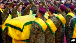 Hezbollah fighters surround the coffin of Abbas Raad, son of the head of Hezbollah's parliamentary bloc, Mohammed Raad, who was killed by an Israeli strike, during his funeral procession in Jbaa, Lebanon, Nov. 23, 2023.