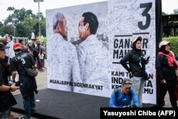 Para pendukung tampak menunggu menjelang kampanye pemilihan calon presiden dan mantan Gubernur Jawa Tengah Ganjar Pranowo dan calon wakil presiden Mahfud MD di Stadion Gelora Bung Karno Jakarta pada 3 Februari 2024. (Foto: Yasuyoshi Chiba/AFP)