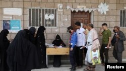 FILE - Beneficiaries of World Food Program assistance queue at a food distribution center amid exacerbating food shortages, in Sanaa, Yemen, July 18, 2023. 