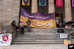 Signs denouncing the closure of the University of the Arts are seen at Dorrance Hamilton Hall on June 14, 2024, in Philadelphia. The closure of the university has left some 1,300 students scrambling to find somewhere to go or something to do. (AP Photo/Joe Lamberti)