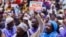 A man holds up a sign that reads 'vote no on the referendum' during a march against the new constitution organized by the Association of Imams, in Bamako, on June 16, 2023. 