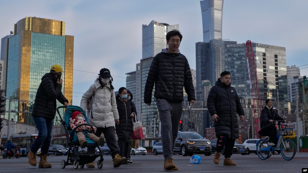资料照片：行人穿过北京中心商务区办公楼附近的交通路口。（2024年2月8日）(photo:VOA)