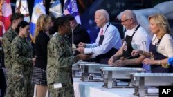 President Joe Biden, chef Robert Irvine, and first lady Jill Biden help serve early Thanksgiving meals to service members and their relatives at the Norfolk Naval Station in Norfolk, Virginia, Nov. 19, 2023.