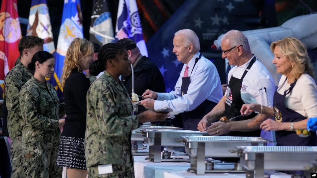 2023年11月19日，总统乔·拜登、厨师罗伯特·欧文和第一夫人吉尔·拜登在弗吉尼亚州诺福克的诺福克海军基地帮助为军人及其亲属提前提供感恩节大宴。 （美联社图片）(photo:VOA)