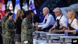 2023年11月19日，总统乔·拜登、厨师罗伯特·欧文和第一夫人吉尔·拜登在弗吉尼亚州诺福克的诺福克海军基地帮助为军人及其亲属提前提供感恩节大宴。 （美联社图片）