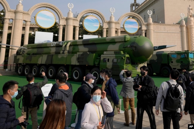 FILE - Visitors tour past military vehicles carrying the Dong Feng 41 and DF-17 ballistic missiles at the Beijing Exhibition Hall in Beijing on Oct. 12, 2022. (AP Photo/Andy Wong)