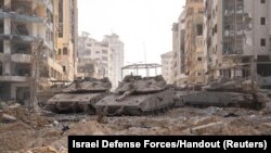 ফিলিস্তিনি সশস্ত্র সংগঠন হামাসের বিরুদ্ধে চলমান স্থল অভিযানের মাঝে ইসরাইলি সামরিক পরিবহন গাজা ভূখণ্ডে অবস্থান নিয়েছে (১২ নভেম্বর, ২০২৩) 