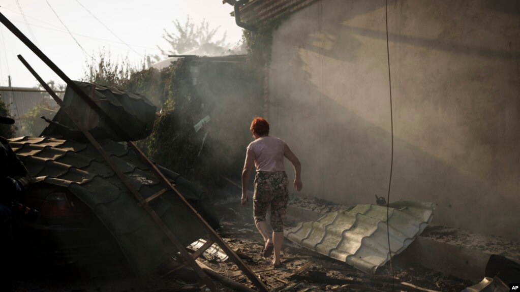 乌克兰赫尔松地区一名妇女走在被俄罗斯炸毁的房屋前。(2023年6月9日)(photo:VOA)