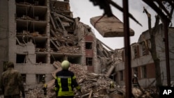 จนท.ดับเพลิงเขาดูแลอาคารแห่งหนึ่งที่ถูกทำลายไปบางส่วนจากการยิงถลมโดยรัสเซีย ในเมืองเชอร์นิฮิฟ ประเทศยูเครน เมื่อ 17 เม.ย. 2567