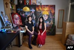 流亡英国的香港夫妻档艺术家淋漓（Lumli）和淋浪（Lumlong 左）在他们的画室里。（2023年6月15日）