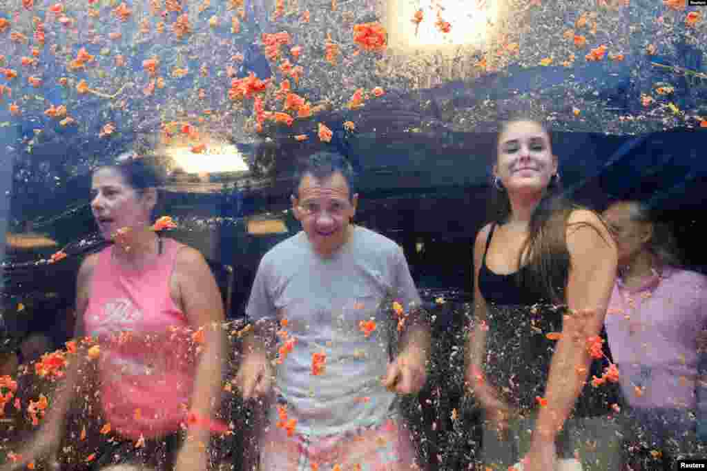 Residentes locales miran desde una ventana cubierta de pulpa de tomate el día del festival anual de peleas de comida 'La Tomatina' en Buñol, cerca de Valencia, España, el 28 de agosto de 2024.