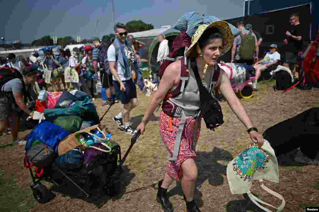 Revelers haul luggage as they arrive at Worthy Farm in Pilton, Somerset for the Glastonbury Festival, Britain.