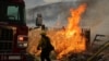 Seorang petugas pemadam kebakaran mendekati api saat kebakaran di Riverside County, California, 14 Juli 2023, sebagai ilustrasi. Enam orang, termasuk tiga anak-anak, tewas dalam kebakaran yang menghancurkan sebuah rumah di barat daya Atlanta. (Foto: AFP)