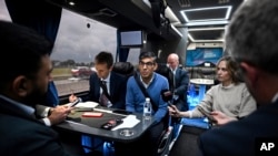Britain's Prime Minister and Conservative Party leader, Rishi Sunak, center, speaks with journalists aboard the party campaign bus on its way to Grimsby, England, June 12, 2024, ahead of the UK General Election on July 4. 
