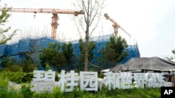 FILE - The Country Garden One World City project under construction is seen on the outskirts of Beijing, Aug. 17, 2023. Real estate difficulties in China have led to construction issues and labor protests. 
