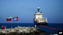 Sebuah kapal menguraikan kabel fiber optik dari pelampung di lepas pantai La Guaira di pesisir Venezuela pada 22 Januari 2011. (Foto: AP/Ariana Cubillos)