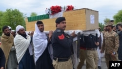 Relatives and security officials carry a coffin of one of the policeman who was killed by a roadside bomb in Lakki Marwat district of Khyber Pakhtunkhwa province on March 30, 2023.
