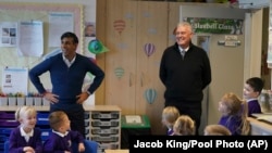 Perdana Menteri Inggris Rishi Sunak dan anggota parlemen Ashfield Lee Anderson mengunjungi Sekolah Dasar Woodland View, di Sutton-in-Ashfield, Nottinghamshire, Inggris, 4 Januari 2024. (Foto: Jacob King/Pool via AP)