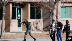 Para anggota kepolisian bergerak masuk ke area kampus Universitas Nevada, Las Vegas, setelah laporan penembakan di kampus tersebut muncul pada 6 Desmeber 2023. (Foto: Steve Marcus/Las Vegas Sun via AP)