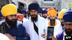 FILE - 'Waris Punjab De' chief Amritpal Singh (C) pays his respect at the Golden Temple in Amritsar on March 3, 2023. 