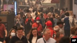 FILE - People wear face masks as they walk outside in the smoke-filled air in Herald Square, June. 7, 2023, in New York.