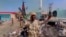FILE: A member of the RSF forces walks around the destroyed Air Defence Forces command site in Khartoum, Sudan, in this screengrab obtained from a social media video on June 14, 2023. (RSF via Twitter/via Reuters)
