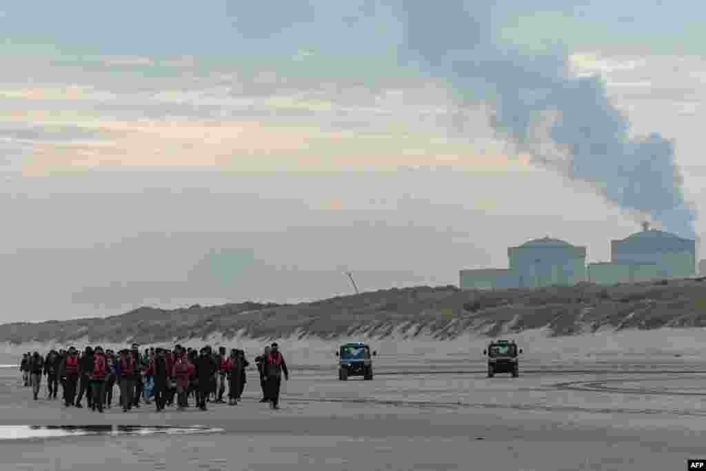 Migrants return inland after being prevented from boarding smugglers&#39; boats by French National Police on the beach of Gravelines, northern France.