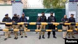 Police stand guard at the provincial election commission as supporters of former Prime Minister Imran Khan's party, the Pakistan Tehreek-e-Insaf, gather demanding free and fair results a day after general elections in Karachi, Pakistan, Feb. 9, 2024.