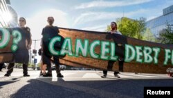 FILE - A small group of protestors block a street near the International Monetary and Financial Committee (IMFC) plenary session at the International Monetary Fund Building in Washington, Apr. 14, 2023. 