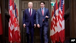Presiden AS Joe Biden dan Perdana Menteri Kanada Justin Trudeau berjalan berdampingan di Parlemen Kanada di Ottawa, Jumat 24 Maret 2023.
