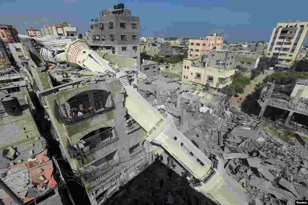 The collapsed minaret of Abdullah Azzam mosque leans against a house after the mosque was hit by an Israeli strike, amid the Israel-Hamas conflict, in Nuseirat refugee camp in the central Gaza Strip.