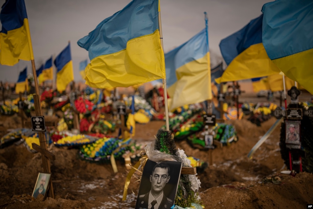 La imagen de un soldado ucraniano, en su tumba en la sección conocida como Callejón de la Gloria del cementerio de Járkov, Ucrania, el 24 de febrero de 2023. (AP Foto/Vadim Ghirda). La guerra ha cobrado la vida de más de 10.000 civiles y dejó a casi 20.000 heridos, según Naciones Unidas. 
