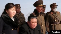 Pemimpin Korera Utara Kim Jong Un dan putrinya Kim Ju Ae (kiri) menyaksikan uji coba rudal di sebuah lokasi di Korea Utara dalam foto yang dirilis oleh kantor berita pemerintah KCNA pada 20 Maret 2023. (Foto: KCNA via Reuters)