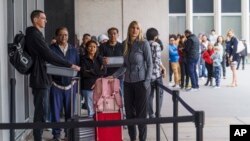 Marni Larsen of Holladay, Utah, waits outside the Los Angeles Passport Agency in Los Angeles, June 14, 2023.