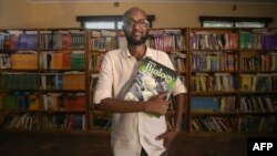 This handout picture taken on Nov. 8, 2023, shows Abdullahi Mire, winner of the U.N. refugee agency's prestigious Nansen Award posing for a picture in one of the libraries he established in Kenya's Dadaab refugee camp. (AFP Photo/UNHCR)