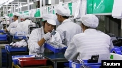 中国广东东莞一家生产锂离子电池的工厂工人在生产线上。（2022年10月16日）