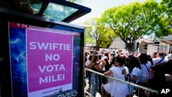 Los fanáticos de Taylor Swift esperan a las puertas del estadio Monumental donde realizará su concierto Eras Tour, donde un cartel dice "Swift no vota por Milei", en referencia al candidato presidencial Javier Milei, en Buenos Aires, Argentina, el 9 de noviembre de 2023.