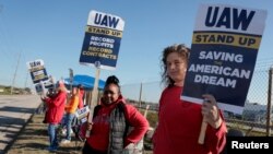 Striking United Auto Workers members hold signs outside the Stellantis Jeep plant in Toledo, Ohio, Sept. 19, 2023. 