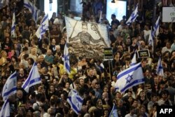 Manifestantes levantan banderas y carteles durante una protesta antigubernamental que pide la liberación de los israelíes tomados como rehenes por militantes palestinos en Gaza desde octubre, en Tel Aviv el 1 de septiembre de 2024.