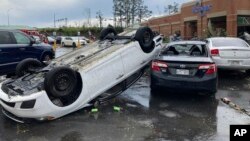 A car is upturned in a Kroger parking lot after a severe storm swept through Little Rock, Ark., March 31, 2023.