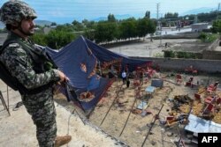 Seorang petugas keamanan berjaga di dekat lokasi ledakan bom di distrik Bajaur, Provinsi Khyber-Pakhtunkhwa pada 31 Juli 2023. (Foto: AFP)