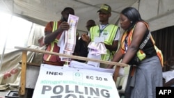 FILE - Officials of the Independent National Electoral Commission (INEC) count votes at a polling station after local elections, in Lagos, March 18, 2023.
