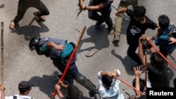 A police officer is beaten by mob during a clash between anti-quota supporters, police and Awami League supporters at the Rampura area in Dhaka, Bangladesh, July 18, 2024.