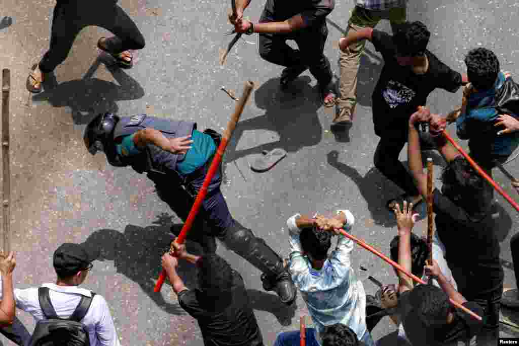 A police officer is beaten by mob during a clash between anti-quota supporters, police and Awami League supporters at the Rampura area in Dhaka, Bangladesh.