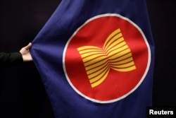 FILE: Seorang pekerja sedang merapikan bendera ASEAN di aula pertemuan di Kuala Lumpur, Malaysia, 28 Oktober 2021. (Lim Huey Teng/REUTERS)