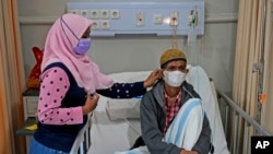 Misnar, seorang pedagang kaki lima yang menderita pneumonia, didampingi putrinya Siti Nurhazanah, dirawat di Rumah Sakit Persahabatan di Jakarta.